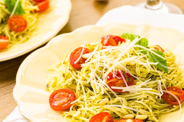 Pasta fatta in casa capelli d'angelo con pesto e pomodorini arrostiti.