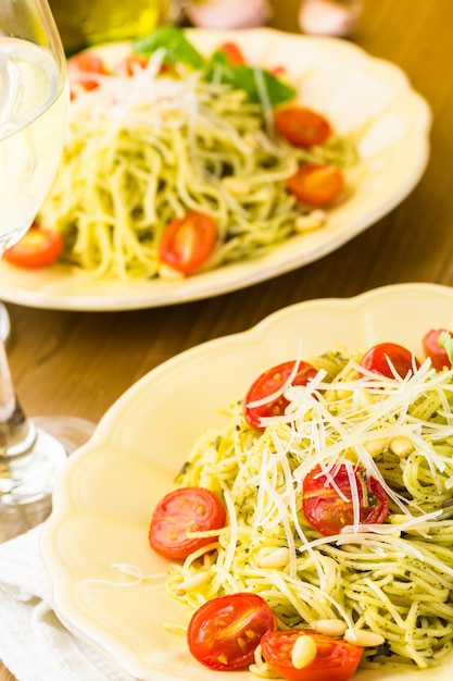 Pasta fatta in casa capelli d'angelo con pesto e pomodorini arrostiti.