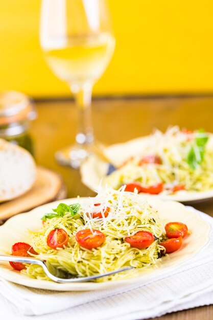 Pasta fatta in casa capelli d'angelo con pesto e pomodorini arrostiti.