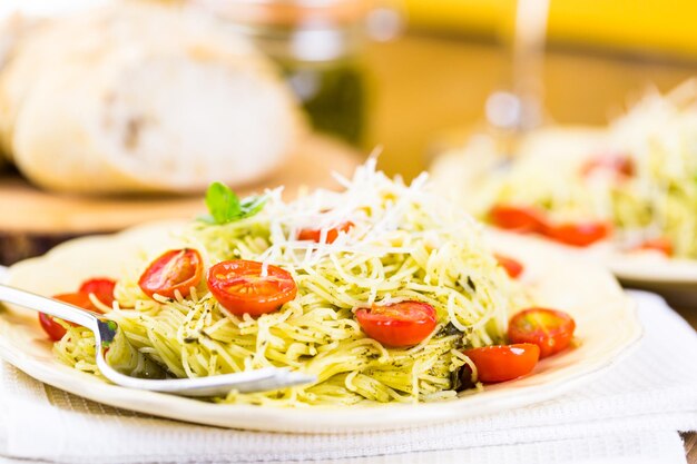 Pasta fatta in casa capelli d'angelo con pesto e pomodorini arrostiti.