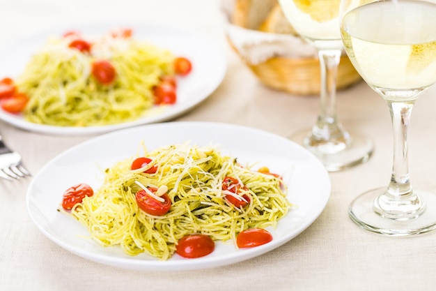 Pasta fatta in casa capelli d'angelo con pesto e pomodorini arrostiti.