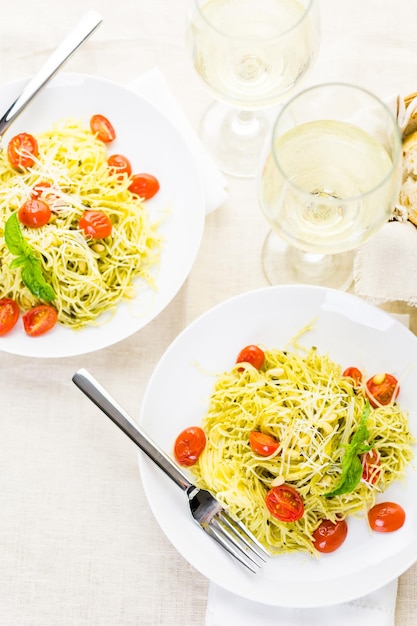 Pasta fatta in casa capelli d'angelo con pesto e pomodorini arrostiti.