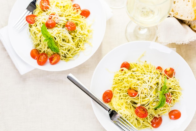 Pasta fatta in casa capelli d'angelo con pesto e pomodorini arrostiti.