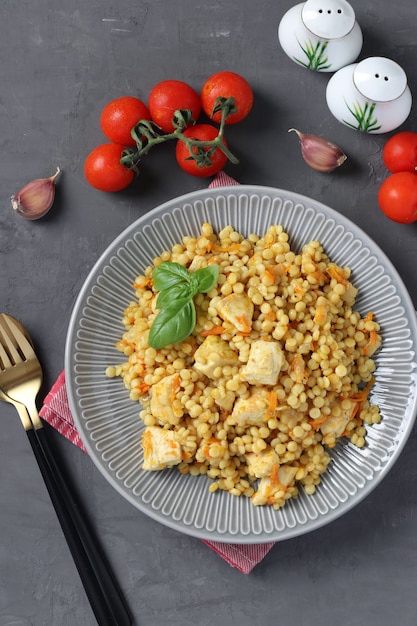 Pasta fatta in casa con pollo e verdure sul tavolo grigio scuro. Vista dall'alto. Formato verticale.