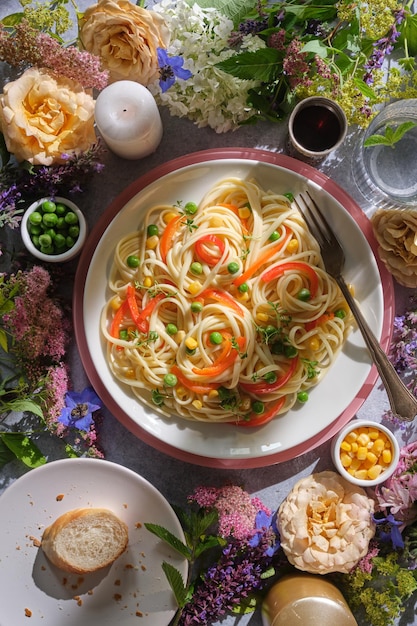 Pasta fresca con piselli verdi, mais e peperoncino, bella cena italiana, luce del tramonto.