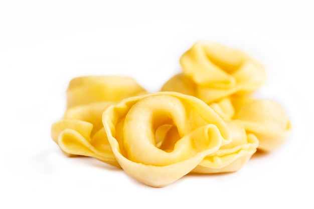 Pasta fresca cruda dei tortellini isolati su fondo bianco