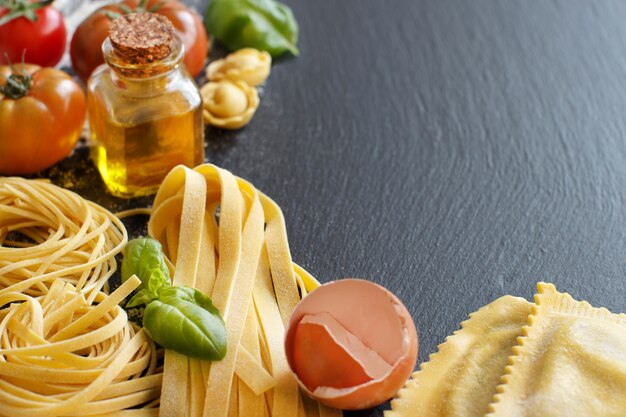 Pasta fresca e ingredienti su una tavola scura