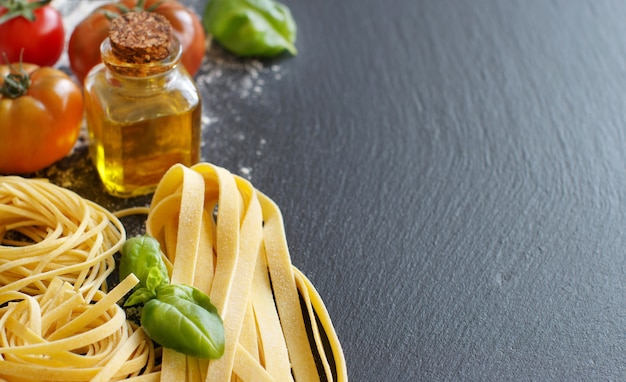 Pasta fresca e ingredienti su una tavola scura