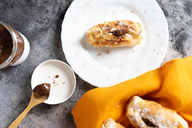 Pasta frolla napoletana ripiena di cioccolato con cestello, tazzina caffè, vasetto e cucchiaio con cioccolato