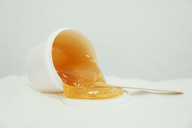 Pasta gialla liquida per shugaring su bianco. Depilazione e cura del corpo