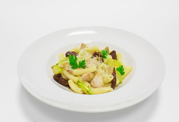 Pasta gourmet con carne di maiale, zucchine e pomodori secchi. Vista dall'alto. Sfondo bianco. Tecnica mista