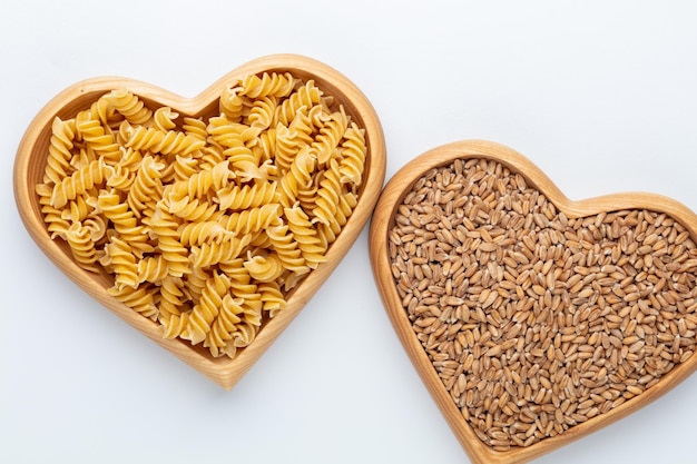 Pasta in una ciotola di legno a forma di cuore