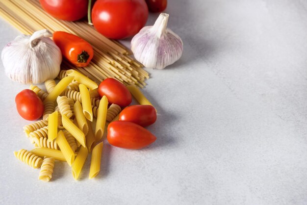 Pasta Integrale Spaghetti Penne Pomodori Aglio Peperoni Verdure su sfondo grigio Italiano