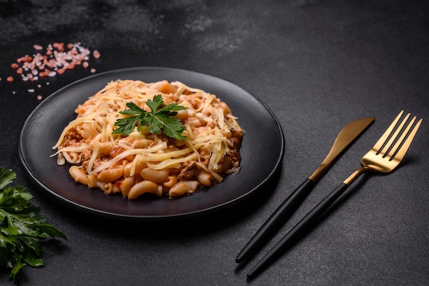 Pasta italiana classica saporita e appetitosa con salsa di pomodoro e formaggio sul piatto su fondo scuro