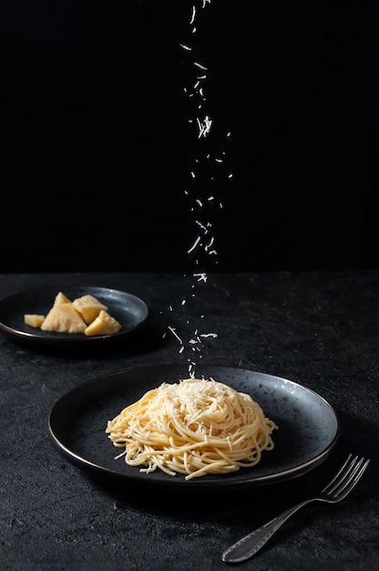 Pasta Italiana Con Formaggio E Pepe. Formaggio spruzzato spaghetti sulla banda nera