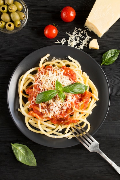 Pasta italiana con salsa al pomodoro e parmigiano nella banda nera