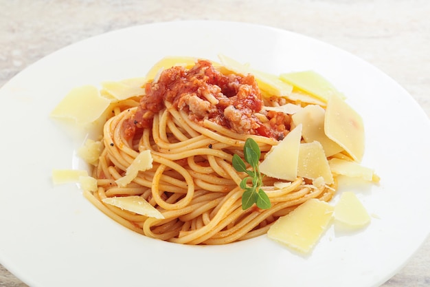 Pasta italiana Spaghetti alla bolognese con parmigiano e foglie di basilico
