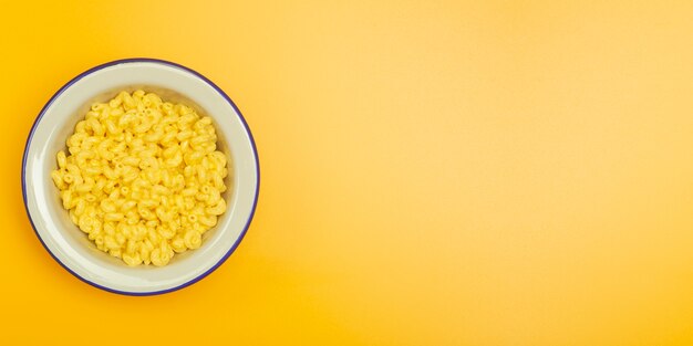 pasta mac e formaggio su una superficie gialla