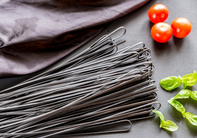 Pasta nera cruda con basilico e pomodori