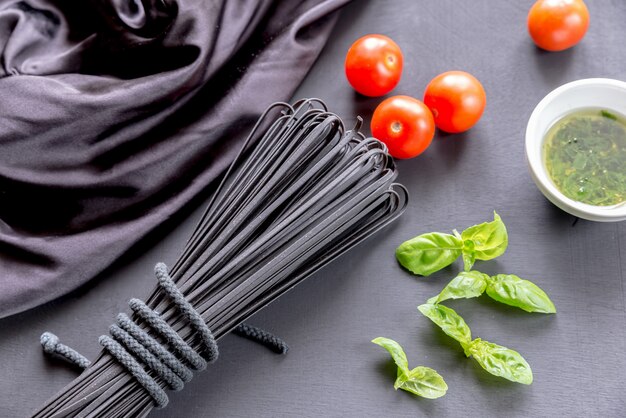 Pasta nera cruda con basilico e pomodori