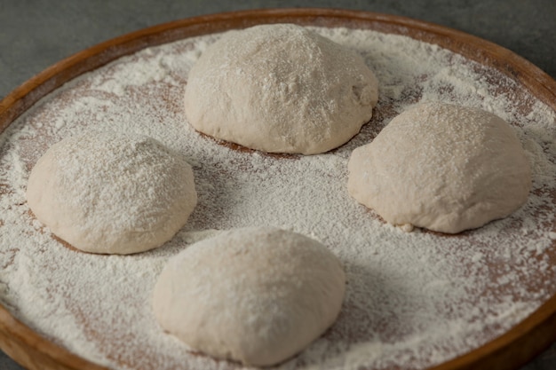 Pasta per pizza e farina sul tagliere