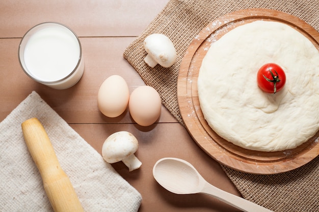 Pasta per pizza su una tavola di legno