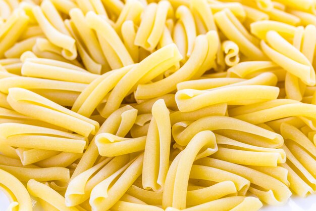 Pasta secca biologica su sfondo bianco.