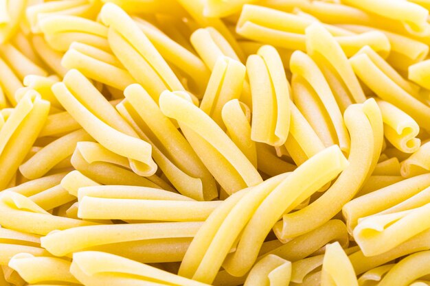 Pasta secca biologica su sfondo bianco.