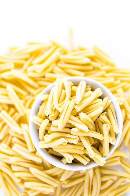 Pasta secca biologica su sfondo bianco.