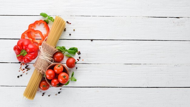 Pasta secca Pasta e verdure fresche Vista dall'alto su fondo di legno bianco Spazio per la copia libero