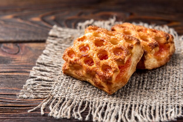 Pasta sfoglia con la mela sulla tavola di legno scuro.