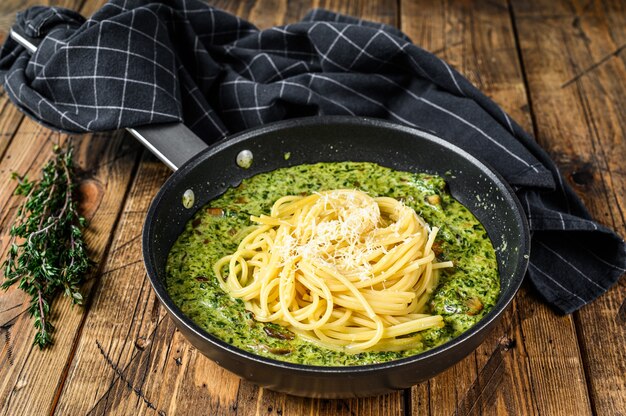 Pasta spaghetti al pesto e spinaci freschi e parmigiano in padella