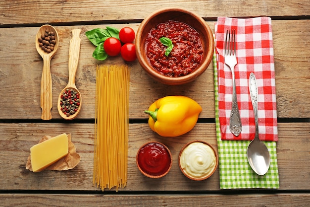 Pasta spaghetti con salsa di pomodoro bolognese e basilico su tavola in legno rustico