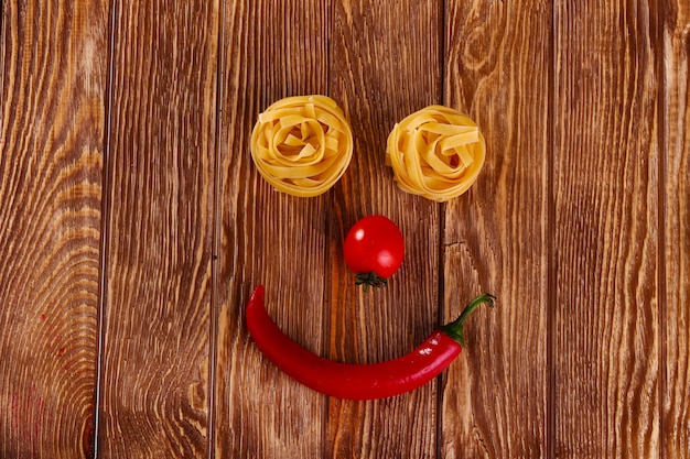 pasta su fondo di legno con pomodoro e pepe