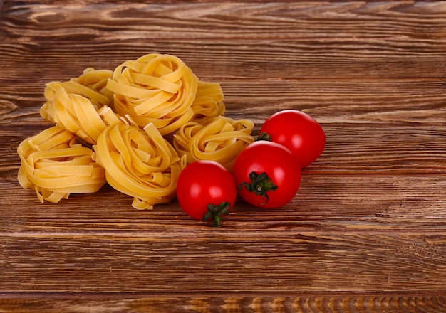 Pasta su fondo in legno con pomodoro