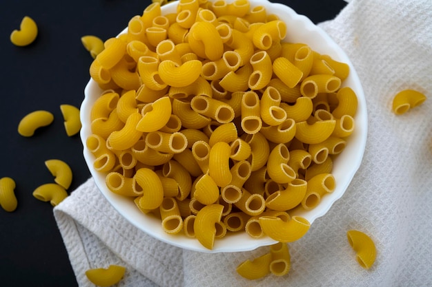 Pasta su un piatto. Pasta cruda in tavola. cucinare la pasta