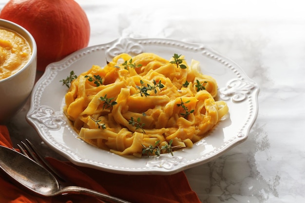 Pasta Tagliatelle con salsa di crema di zucca su sfondo nero