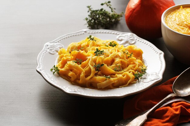 Pasta Tagliatelle con salsa di crema di zucca su sfondo nero