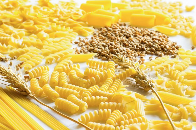 Pasta, tagliatelle, ramoscello di grano e grano sul tavolo