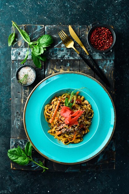 Pasta vegana con pomodori, sedano e zenzero Su fondo di pietra nera