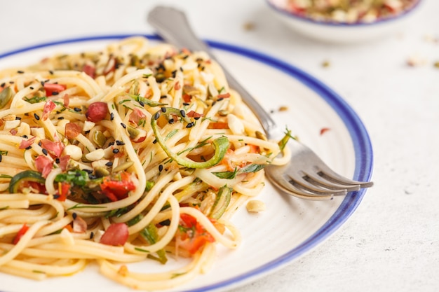 Pasta vegana sana con zucchine, pomodori e noci.