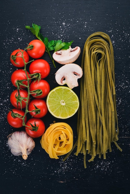 Pasta verde secca con spinaci e verdure su sfondo di legno Cucina tradizionale italiana Vista dall'alto Copia spazio