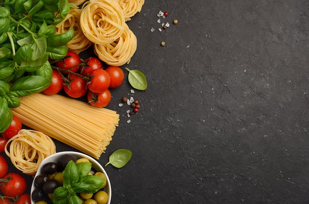 Pasta, verdure, erbe e spezie per il cibo italiano sul nero