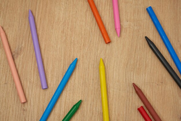 Pastelli a cera multicolore per bambini per disegnare su un tavolo di legno.