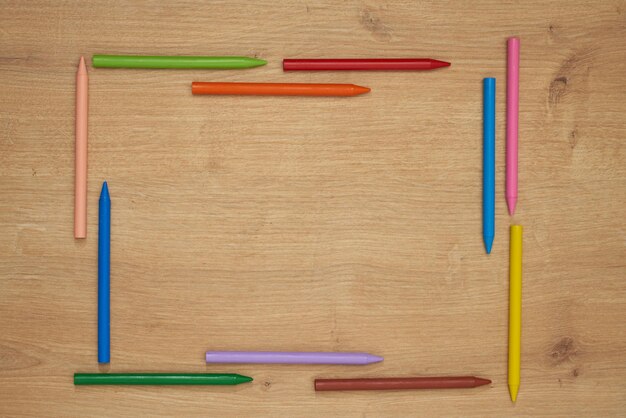 Pastelli a cera multicolore per bambini per disegnare su un tavolo di legno.