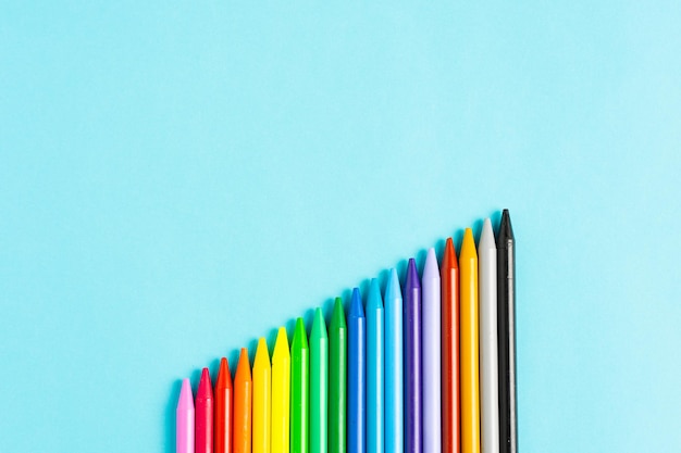 Pastelli colorati su sfondo blu. Crescere sul concetto di business