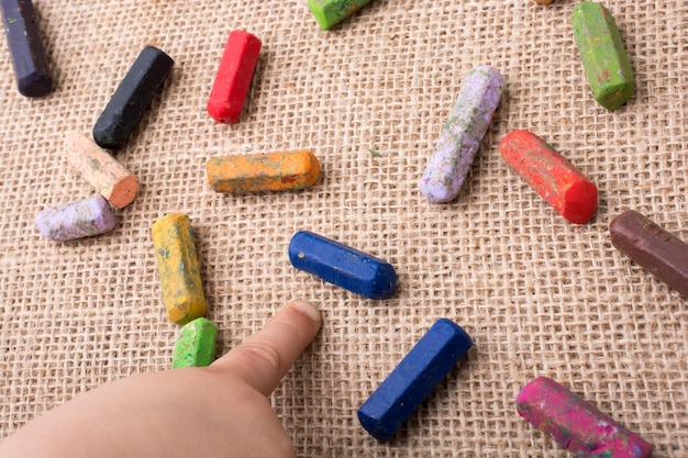 Pastelli colorati usati e la mano di un bambino