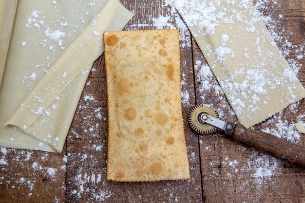 Pastello fritto, pasta e pastello crudo, sulla tavola di legno rustica