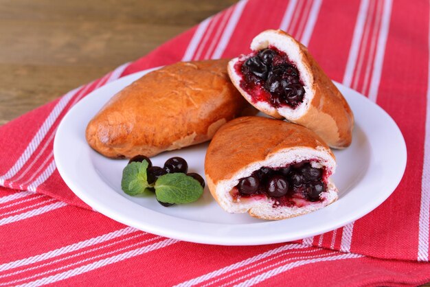 Pasticce fresche al forno con ribes sul piatto sul tavolo da vicino