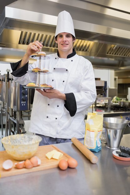 Pasticcere che presenta un vassoio torta a più livelli